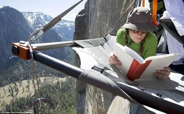 贝卡在登山期间休息时，在悬崖边看书放松。