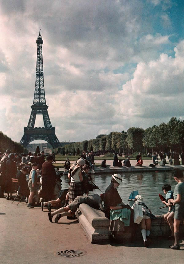 儿童在水池中玩着玩具船，远方的背景是艾菲尔铁塔。照片摄于1936年7月。