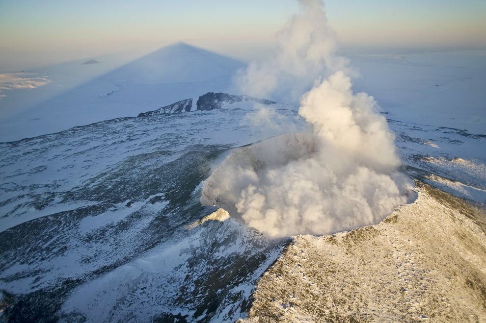 伊里布斯峰在罗斯海投下长长的影子。伊里布斯峰是南极洲最活跃的火山，也是全世界拥有永久熔岩湖的少数几座火山之一。