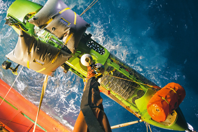 深海挑战者号在深度8221公尺的试潜后，由船上的起重机吊上甲板。橘色的气囊能在上升时增加浮力；灰色的气囊则能将潜水艇调整到水平位置以利回收。