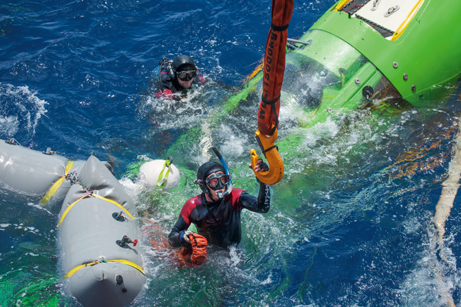 2012年3月26日，成功潜入马里亚纳海沟之后，深海挑战者号在水面载浮载沉，卡梅隆就在里面。要回收潜艇，潜水员必须算准时间：他骑在潜水艇上，得抓住一个晃来晃去的