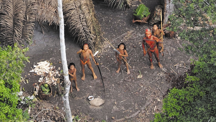 2010年，一个原始部落的居民在看飞机飞过。