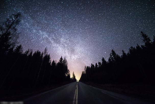 在道路两旁的树林衬托下，芬兰的夜空份外夺目。