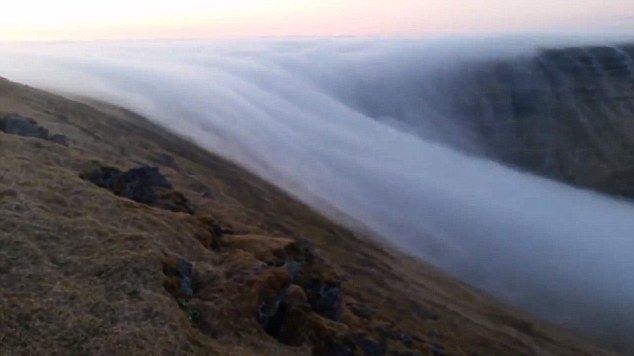 冰岛布雷扎峡湾罕见自然奇观：山顶浓雾如瀑布一般流下海崖