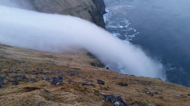 冰岛布雷扎峡湾罕见自然奇观：山顶浓雾如瀑布一般流下海崖