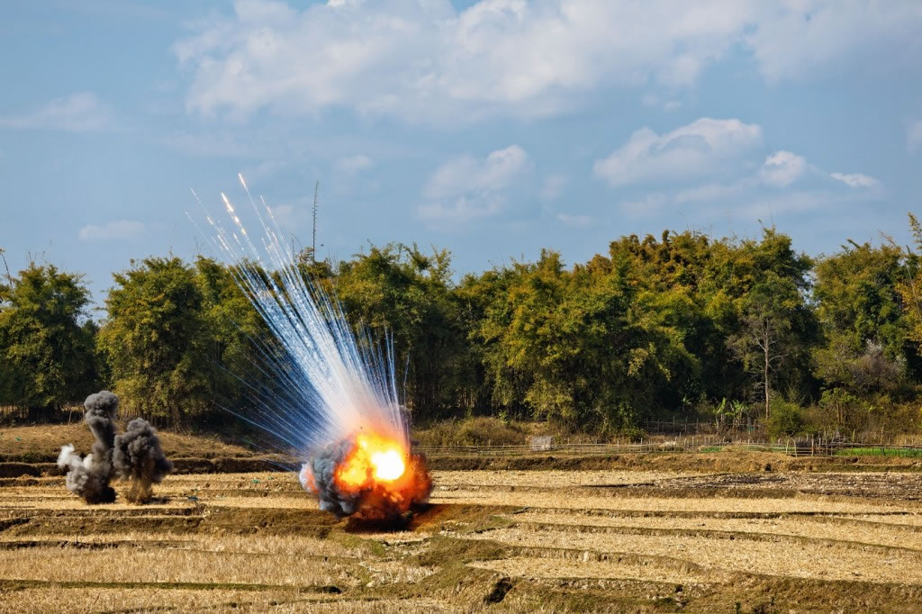 图中的弹药是越战中留下的一部分未爆弹，在2012年被销毁以恢复一片田地的安全。 Photograph by Stephen Wilkes