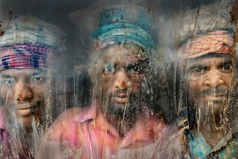 第27届国家地理旅行者摄影大赛二等奖：在孟加拉国吉大港（Chittagong），碎石粉碎场充满了灰尘和沙子。三个碎石工人正透过窗户玻璃看着他们的工作地点。