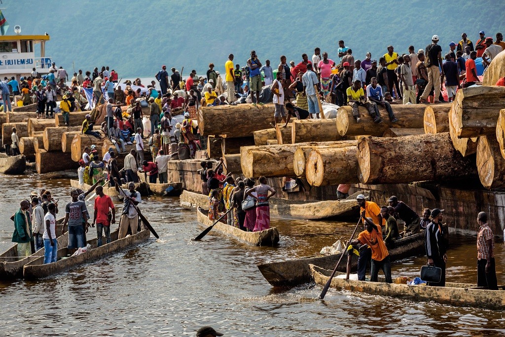 刚果民主共和国的道路稀少，货运驳船通常是旅行的最佳选择。乘客在一堆堆摇摇欲坠的货物中煮饭、睡觉和聊天。 Photograph by Pascal Maitre