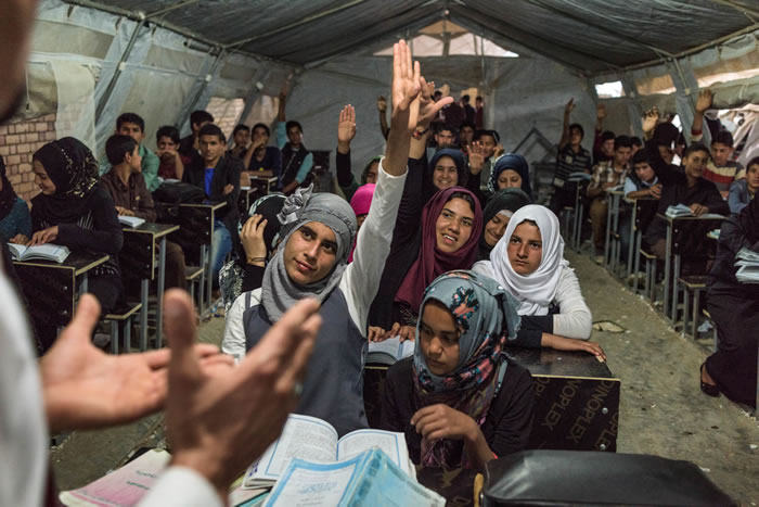 学生在阿尔巴特难民营上课时踊跃举手发言。伊拉克北部的库尔德族政府已收容超过100万人，他们都是从伊拉克与叙利亚逃避伊斯兰国战火的无辜百姓。 Photograph