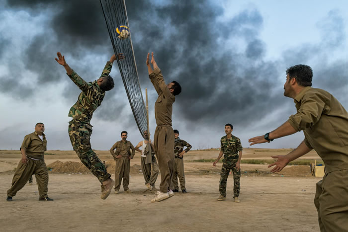 在基尔库克南方，名为自由斗士的库尔德族部队在前线后方打排球。伊斯兰国战士（据信其中也包括前伊拉克陆军军官）自2014年开始在伊拉克境内攻城掠地，自由斗士是少数能
