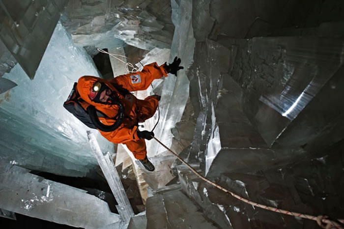 奈卡水晶洞里的温度往往超过摄氏43度，图中一位研究人员全副武装，穿着内含冰块的防护衣，垂降到洞内。探勘这座洞穴的人员，必须先穿上内藏冰袋的背心，再穿上隔热外套，