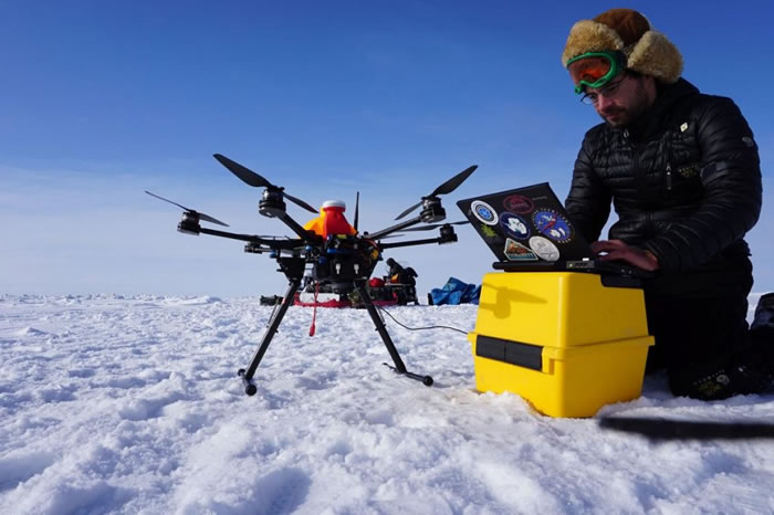 一名阿拉斯加无人机系统整合中心的研究生正在操作空拍机，针对紊乱的冰原进行测绘，协助当地猎人开辟雪地摩托车路线以便前往捕鲸。 PHOTOGRAPH BY ALAS
