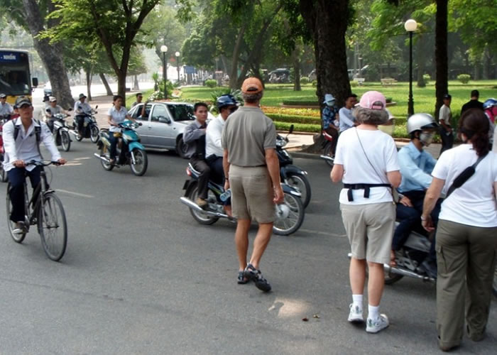 外地人来到越南需学会在车辆中，找到时机过马路。