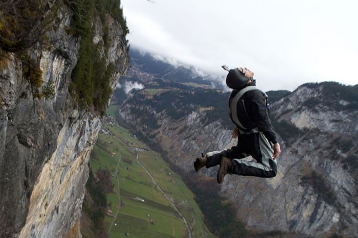 一位定点跳伞运动员在悬崖边后空翻。 PHOTOGRAPH BY OLIVER FURRER, ALAMY PHOTO
