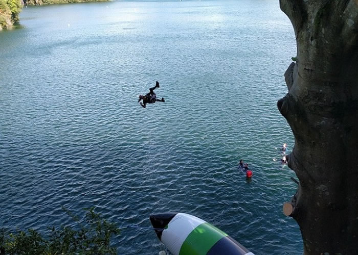 坐在巨型浮床上的人被弹飞上高空再堕入湖中。