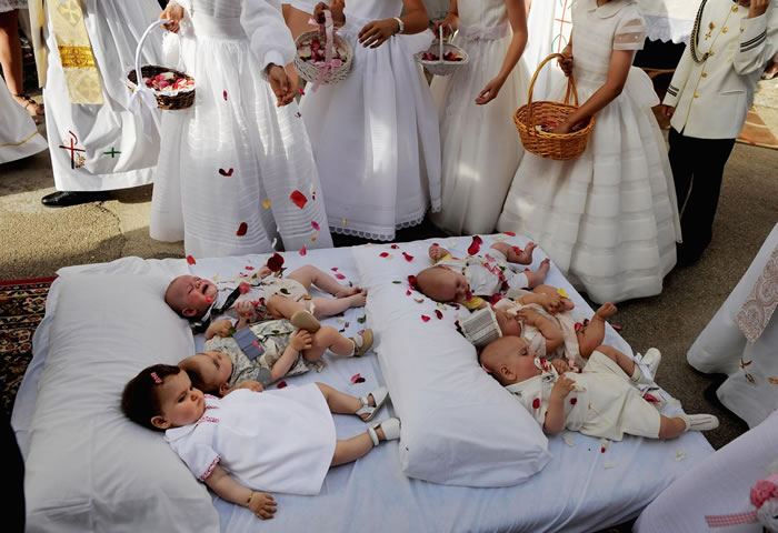 魔鬼消除了婴儿的罪过后，大家会在婴儿身上撒玫瑰花瓣。 PHOTOGRAPH BY DENIS DOYLE, GETTY IMAGES