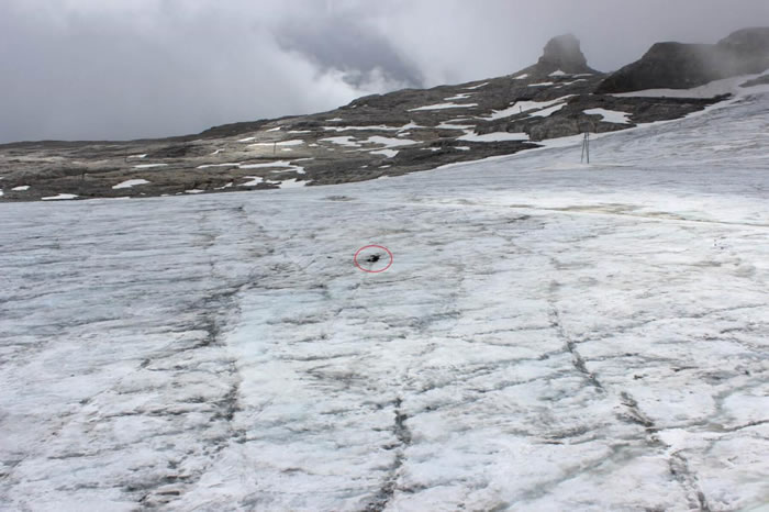 图中以红圈圈起两具遗体，对照出一旁位在瑞士莱迪亚布勒雷高原左近的冰河之比例。 PHOTOGRAPH BY SWISS POLICE