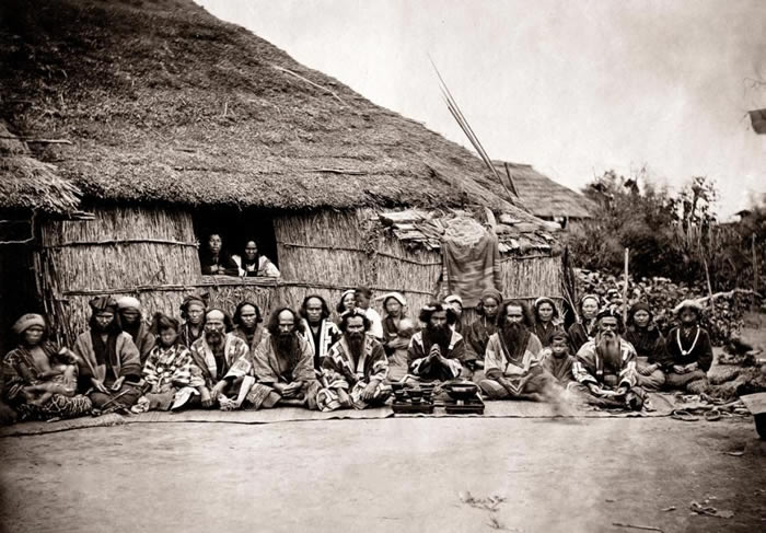 这张1880年代的照片中，一群日本原住民爱奴人席地而坐。语言学家无法在世界上找到任何与爱奴语相似的语言。 PHOTOGRAPH BY PUMP PARK VIN