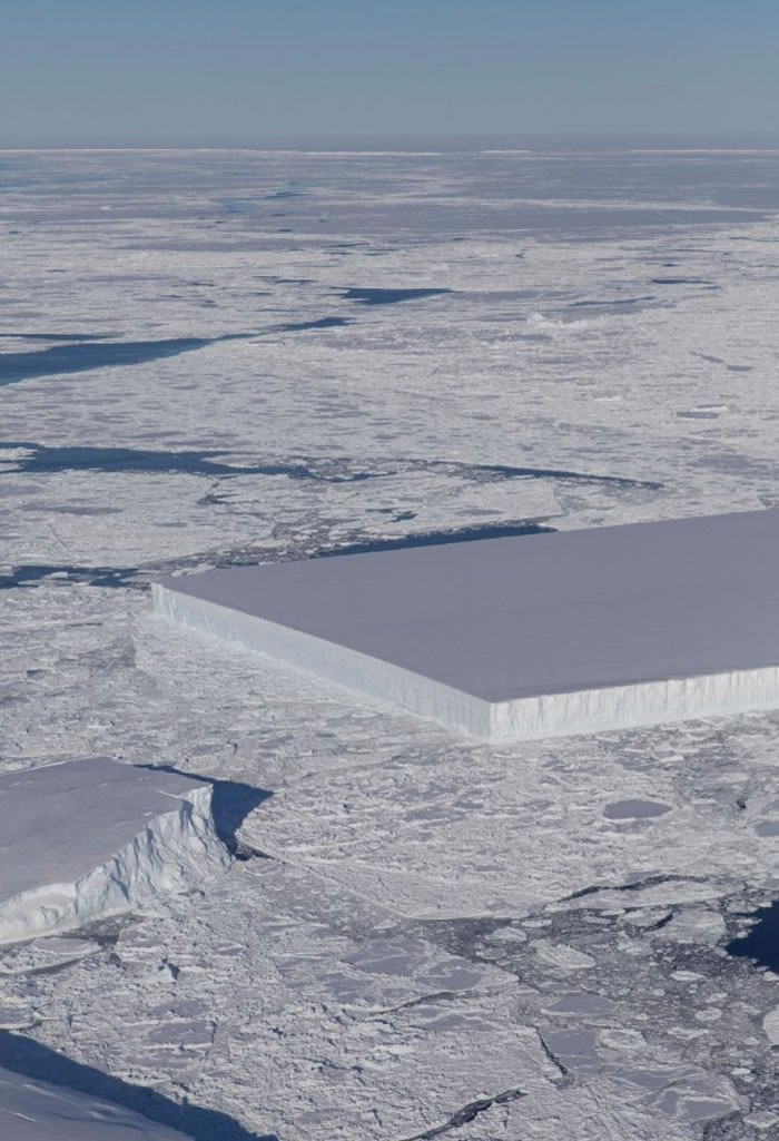 执行冰桥行动的飞机拍摄到的影像：照片右方可以看到一个平板状的冰山漂浮在拉森C冰棚外的海冰之间。这个冰山锐利的角度和平坦的表面显示它可能最近才刚从冰棚崩裂下来。