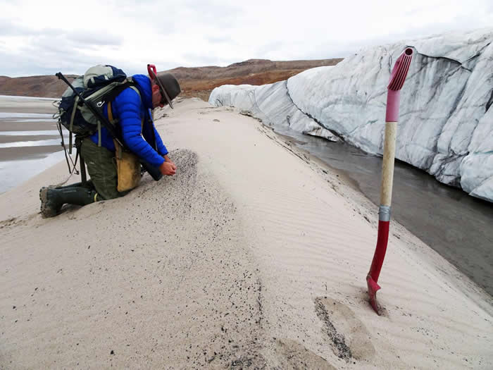 Kurt Kjær在海瓦萨冰川前沿收集沙石样本。该沙石被冰川从陨石坑底部转运至冰盖边缘；它带来了有关该陨石撞击的丰富信息