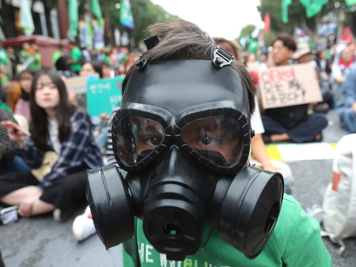 韩国首尔：有小学生戴上防毒面具示威。