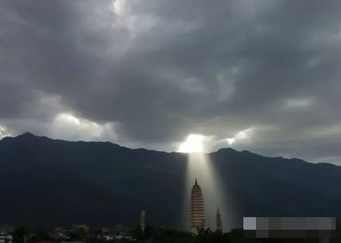 一道“佛光”穿破厚重的云海，直接照射在崇圣寺三塔。