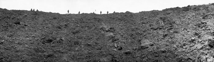 协约国士兵望进梅森之战炸出的陷坑，小小的人影衬托出破坏力的规模。 PHOTOGRAPH BY DAILY MIRROR, MIRRORPIX, MIRRORPI
