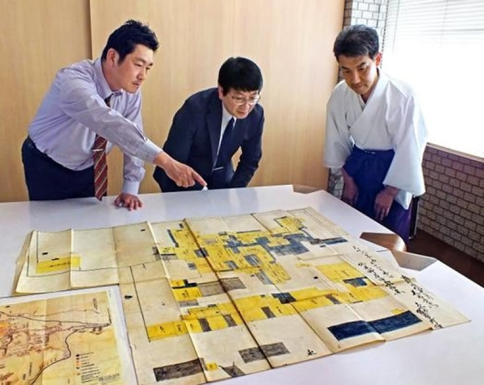 中村武生（左）与宫川祯一（中）共同观看平面图。