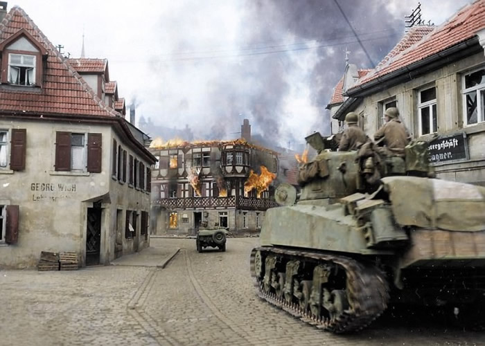 美国陆军装甲师士兵驾驶战车进入小镇。