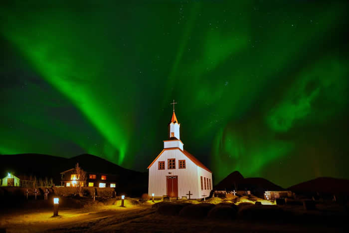 北极光将冰岛这座教堂后方的天空，染成了一片绿色。 PHOTOGRAPH BY RAUL TOUZON, NATIONAL GEOGRAPHIC CREATIVE