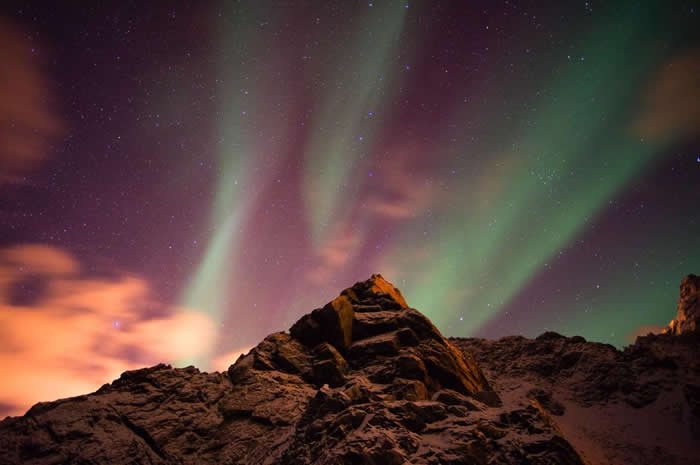在挪威西奥伦群岛（Vesteralen Islands）上的这座山峰，耸立直入满布极光的天空。 PHOTOGRAPH BY SERGIO PITAMITZ, N