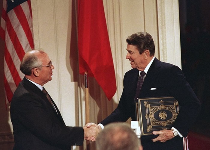 前苏联领袖戈尔巴乔夫（左）与美国总统里根（右）签署《中程导弹条约》。