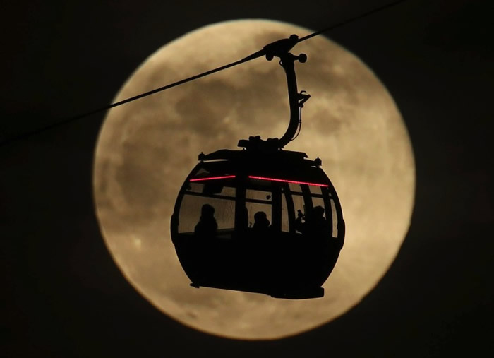 位于英国伦敦的缆车与月亮互相衬托。