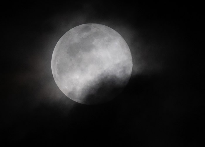 美国看到的圆月被薄雾遮掩。