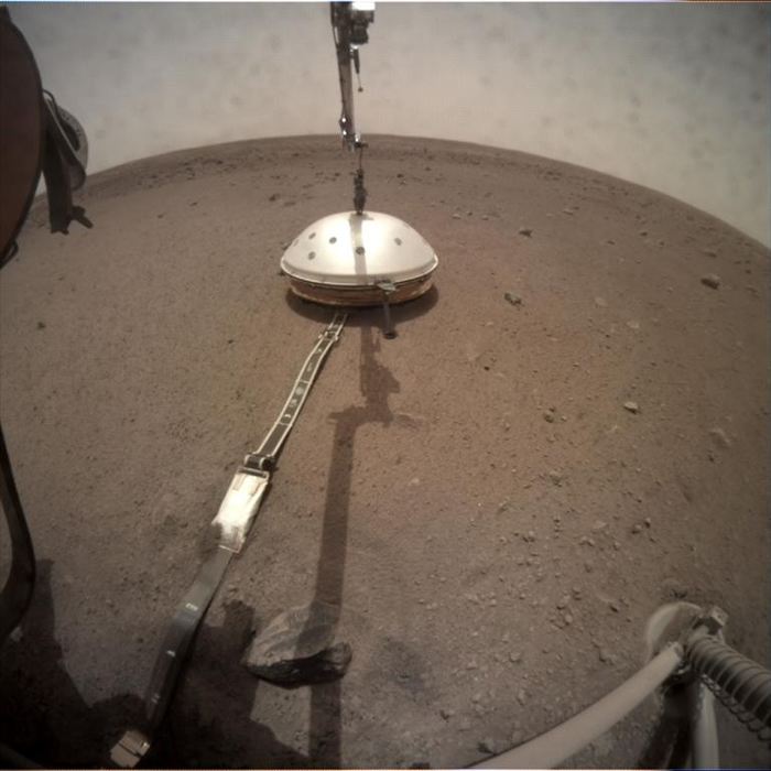 洞察号在2019年2月4日放置了防风隔热罩，保护先前在2018年12月19日于火星表面设置的地震计。 PHOTOGRAPH BY NASA/JPL-CALTEC