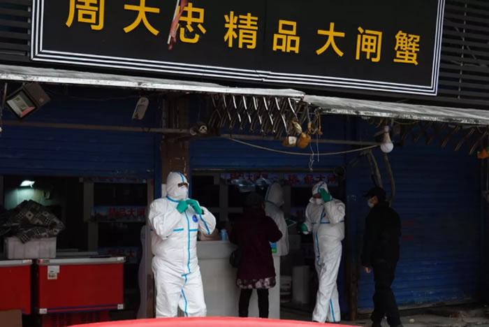 防疫工作人员对华南海鲜市场进行检查。图片来自新京报