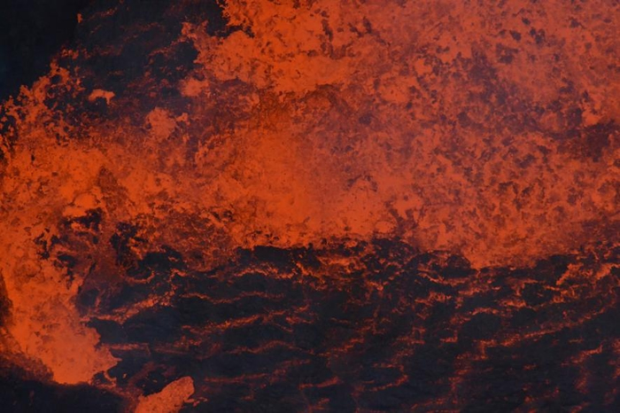 在2018年爆发前，熔岩在安布理姆的一座湖里翻搅。 熔岩湖的作用就像是直通深处的一扇窗，提供了地底深处究竟发生了什么的线索。 PHOTOGRAPH BY DAN