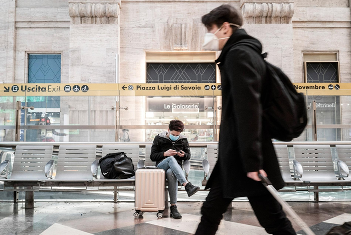 在意大利于3月8日的新版旅游限制生效之前，一名旅客正在等候一班从米兰中央车站出发的火车。 PHOTOGRAPH BY ALESSANDRO GRASSANI,