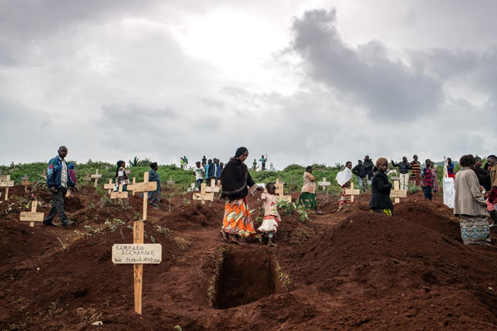 2019年3月2日，厚厚云层之下，成群结队的哀悼者在新坟之间慢慢行走，当时他们正走去参加DRC布滕博的基塔图巴墓园里50岁警察塔布. 阿姆利. 艾曼纽（Tabu