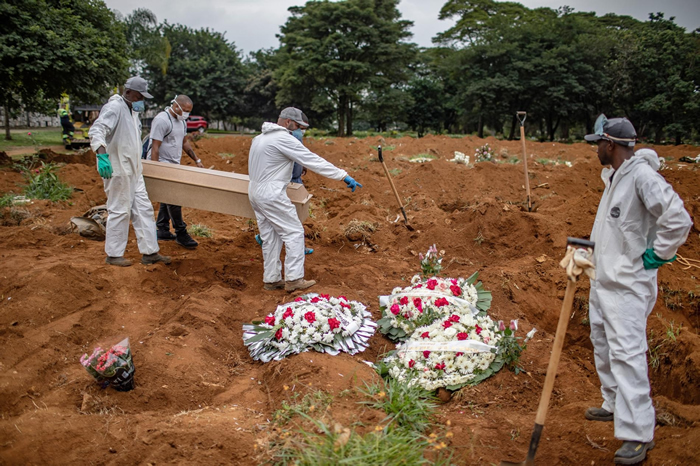 2020年4月7日星期二，几个人在巴西圣保罗的维拉福尔摩沙公墓（Vila Formosa cemetery）埋葬一名死去的冠状病毒患者。 PHOTOGRAPH