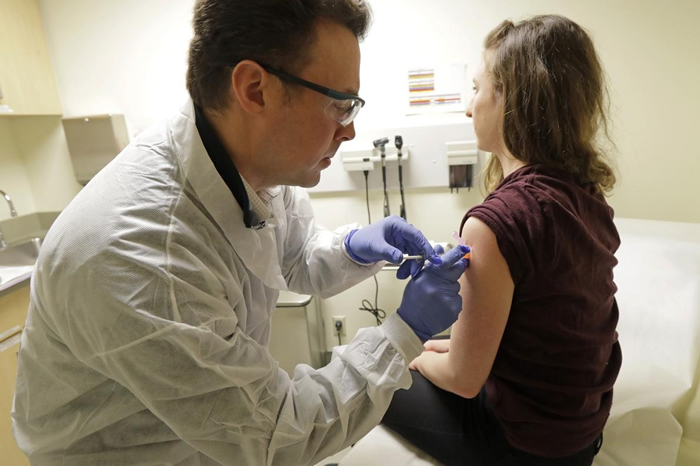 2020年3月16日，药师麦克. 威特（Michael Witte）（左）在一种COVID-19潜在疫苗的临床试验第一阶段为瑞贝卡. 希路尔（Rebecca S