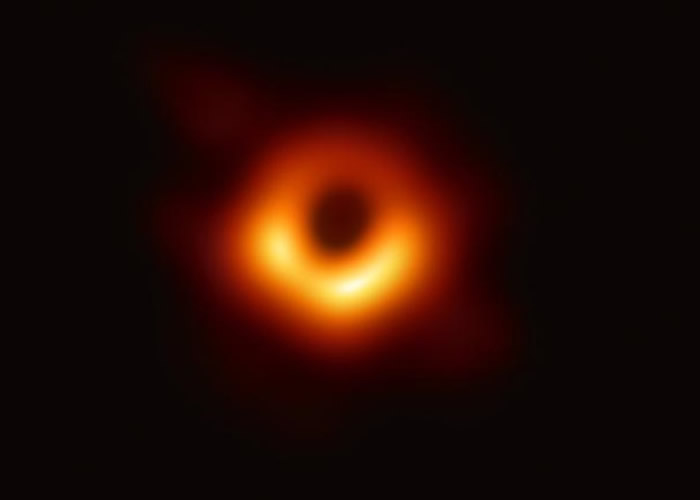首张黑洞图中，明亮的橙色背景下可见黑洞的“影子”。