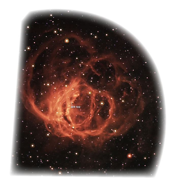 WR 102隐藏在这红外图像拍摄到的星云状物中心。恒星的极端辐射正在电离周围气体，从而使气体发光。