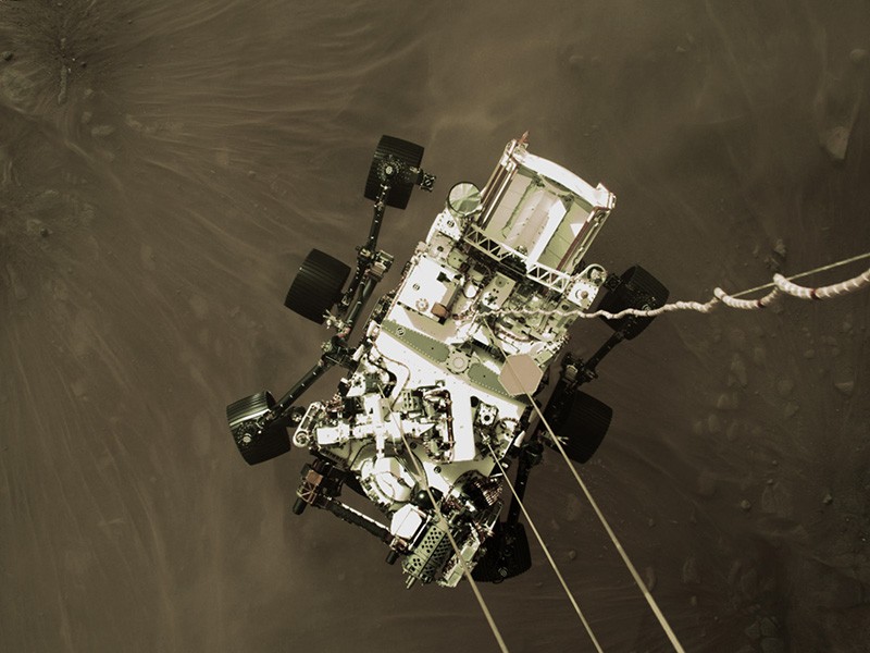 今年2月，一架火箭驱动的“空中起重机”在美国“毅力”号探测器降落到火星表面时拍摄了这张照片。图片来源：NASA/JPL-Caltech