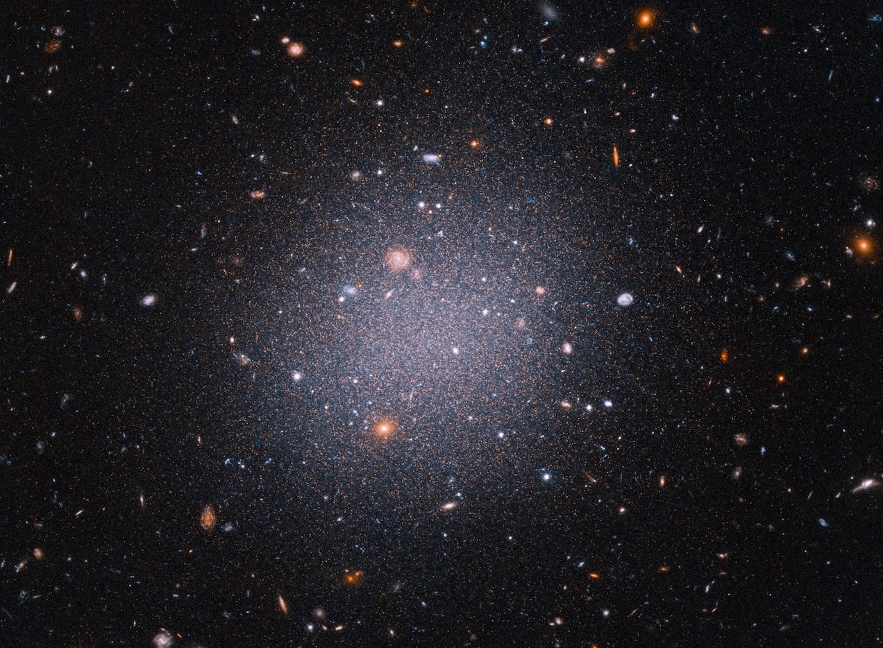 由哈勃太空望远镜拍摄的DF2星系影像，这是个距地球7200万光年远的独特星系。天文学家一直对DF2缺乏暗物质的事实感到困惑，而暗物质像是能将星系结合在一起的隐形